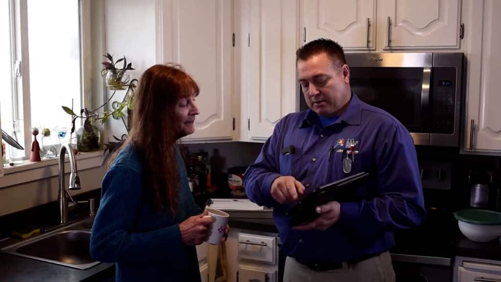 woman and man standing infront of kitchen looking at clipboard going over prices
