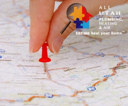 a map with a woman's index finger and thumb pushing a red thumbtack into an unknown location.