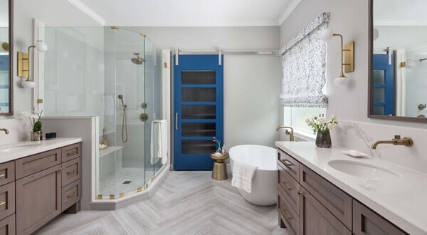 A large bathroom with two sinks, a blue closet door for towels, a glass shower, and a bathtub separate from the shower.